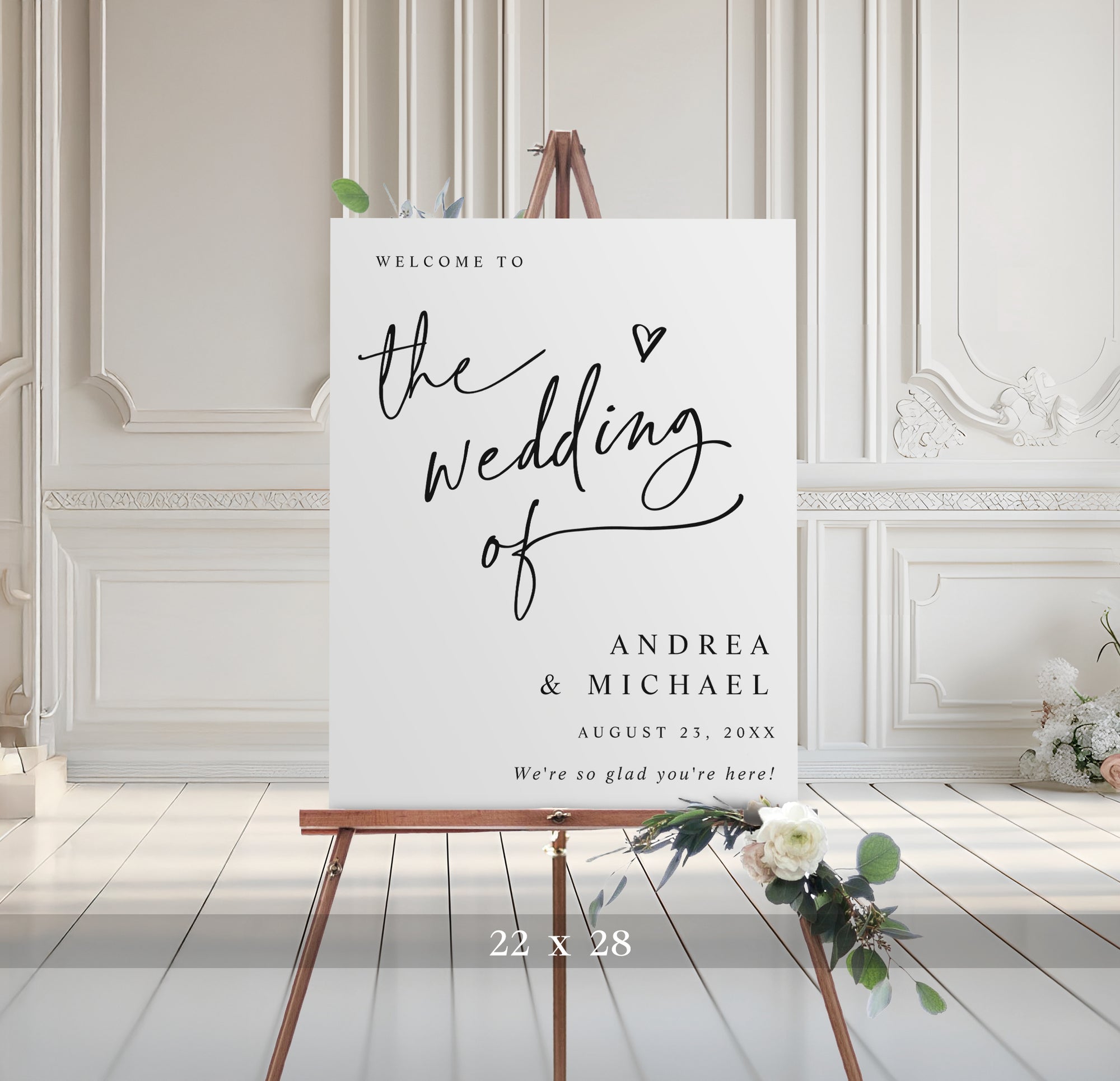Wedding welcome sign on an easel with decorative elements in a room with white paneled walls.