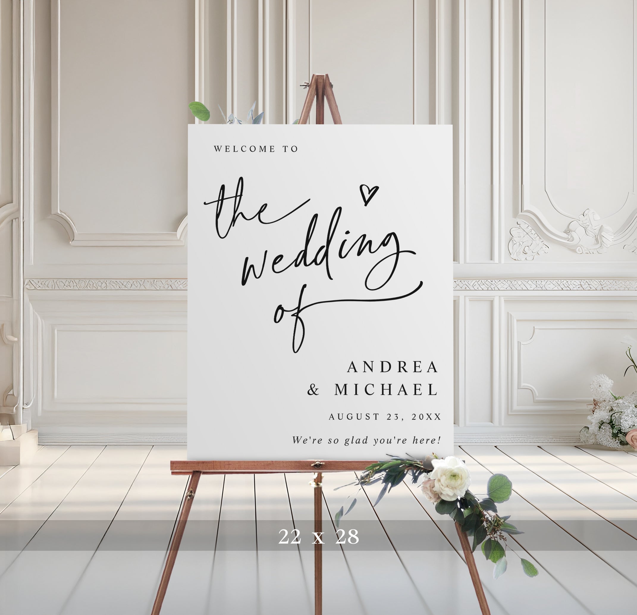 Wedding welcome sign on an easel with decorative elements in a room with white paneled walls.