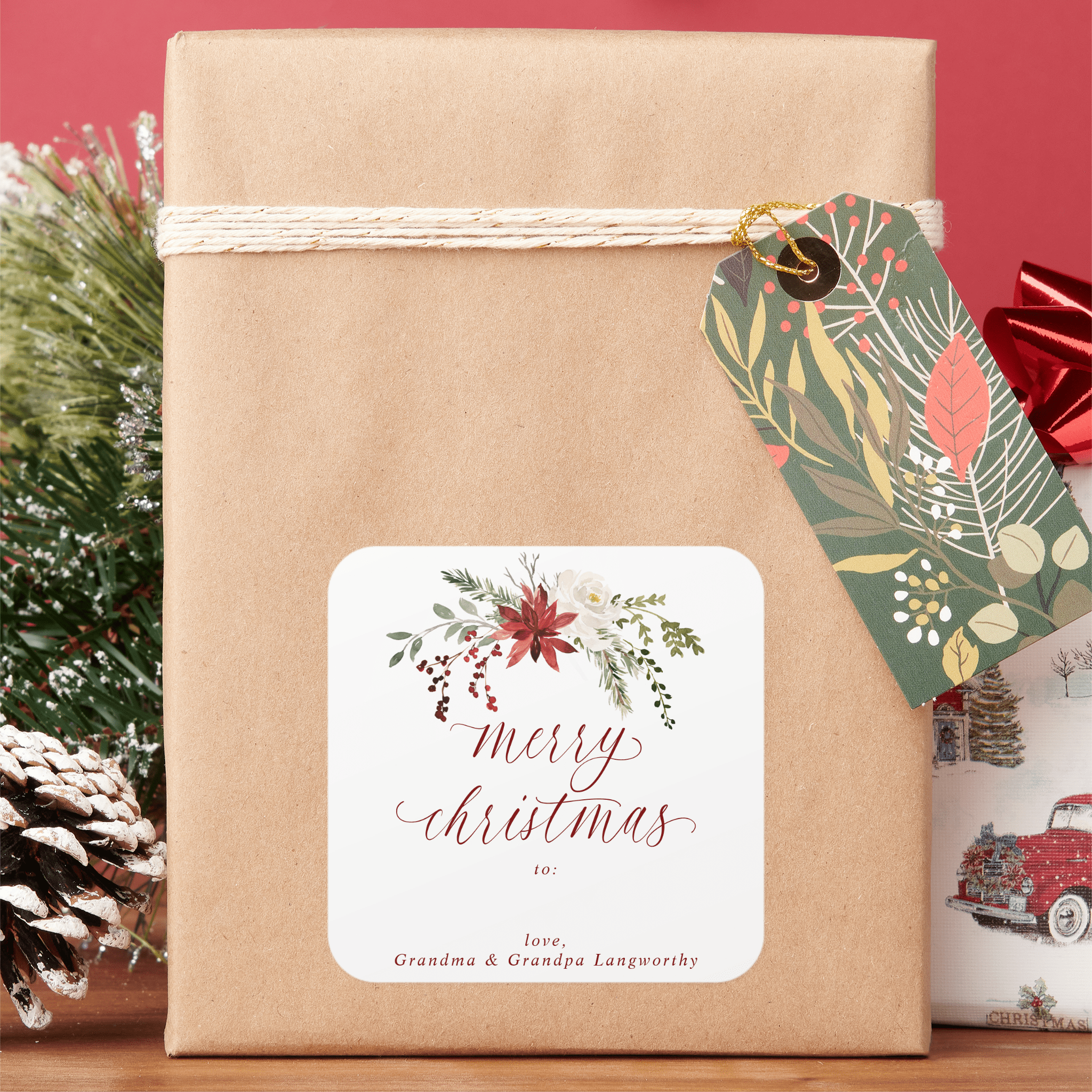 Gift wrapped in brown paper with a decorative tag and 'Merry Christmas' label, set against a red background.