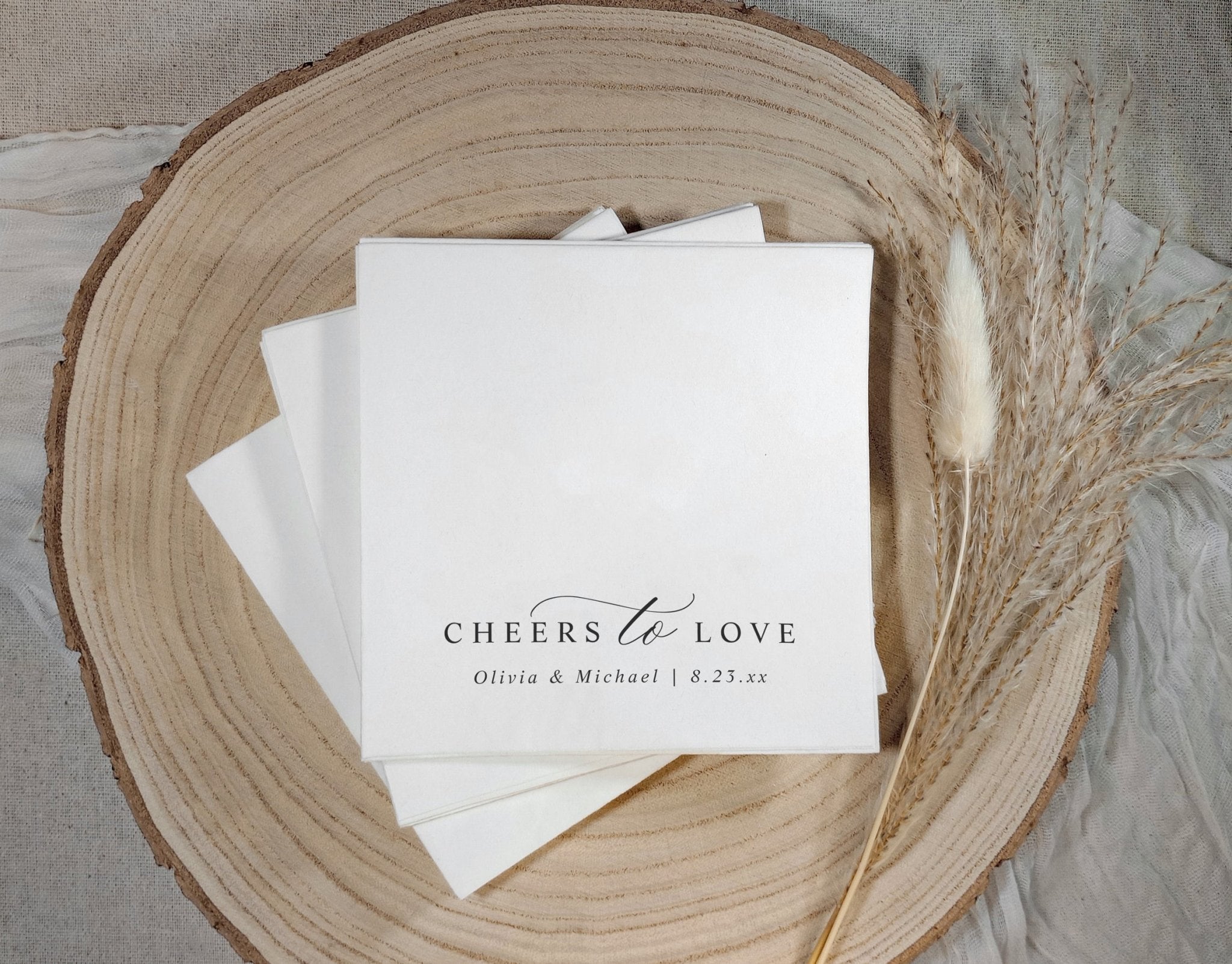 Minimalist modern wedding napkins featuring “cheers to love” in timeless script typography