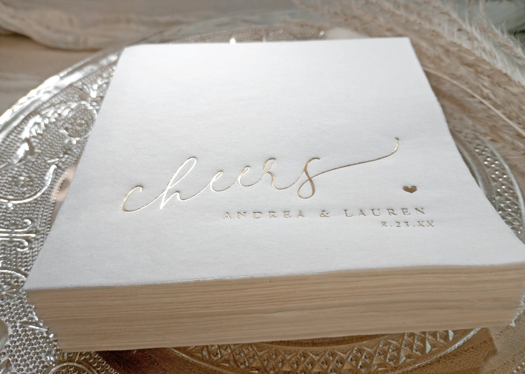 Foil stamped “cheers” napkin with modern calligraphy and personalized names