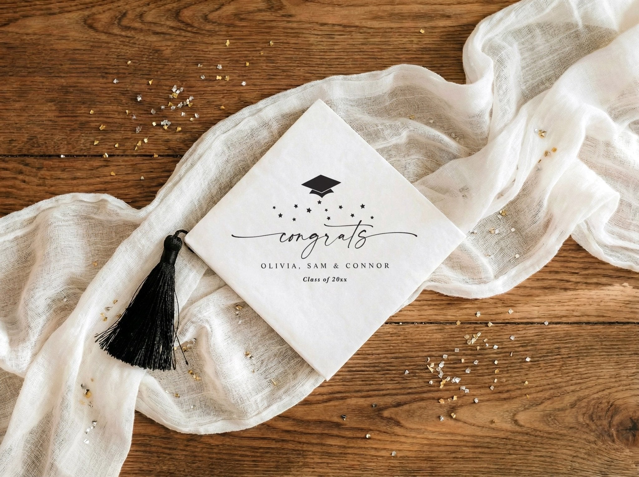 Diagonal graduation napkins with script congrats, stars and graduation cap design