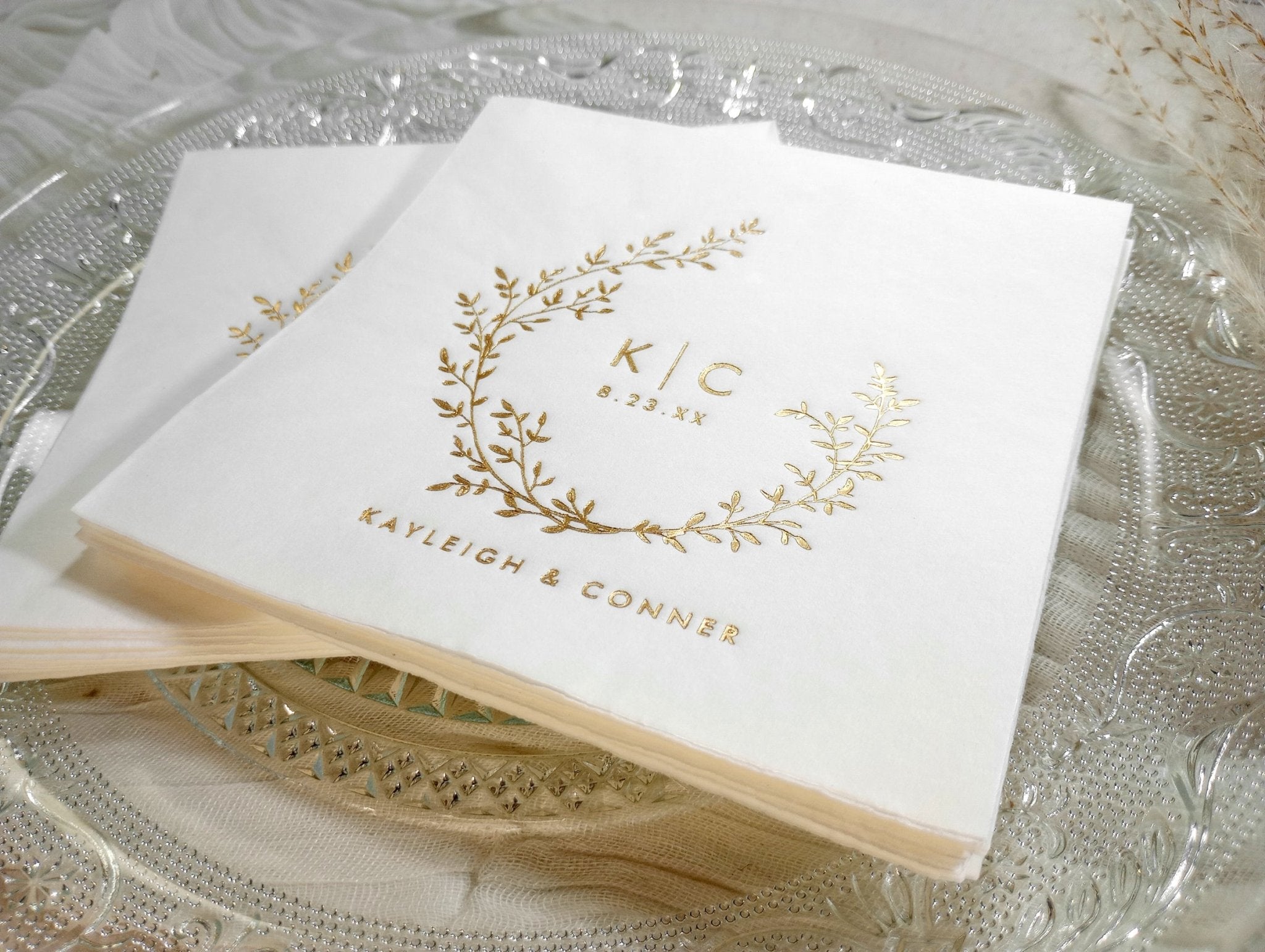 Close up of personalized wedding napkins - gold foil stamped boho vintage wreath design