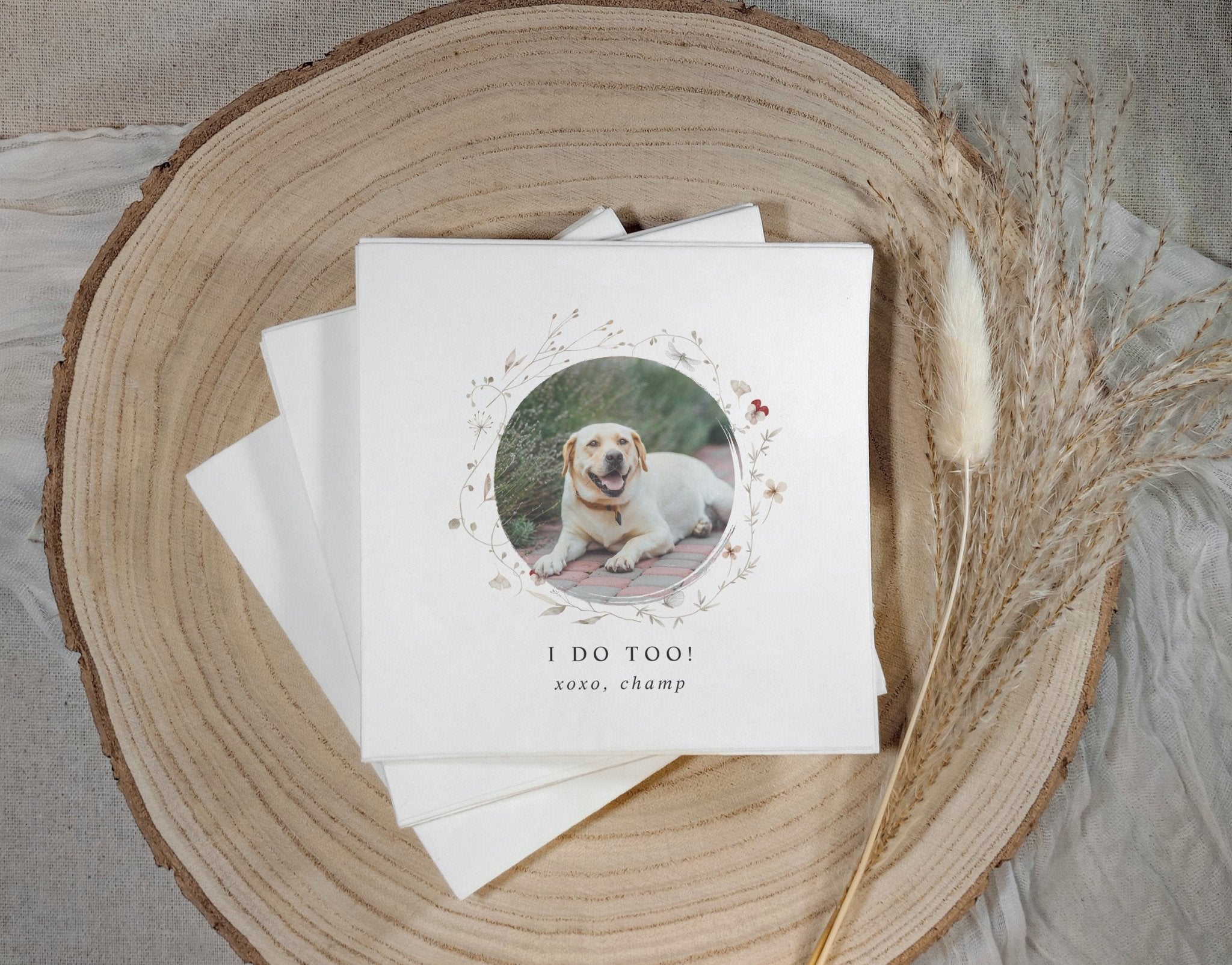 Stack of wedding napkins with a dog photo and text on a wooden surface
