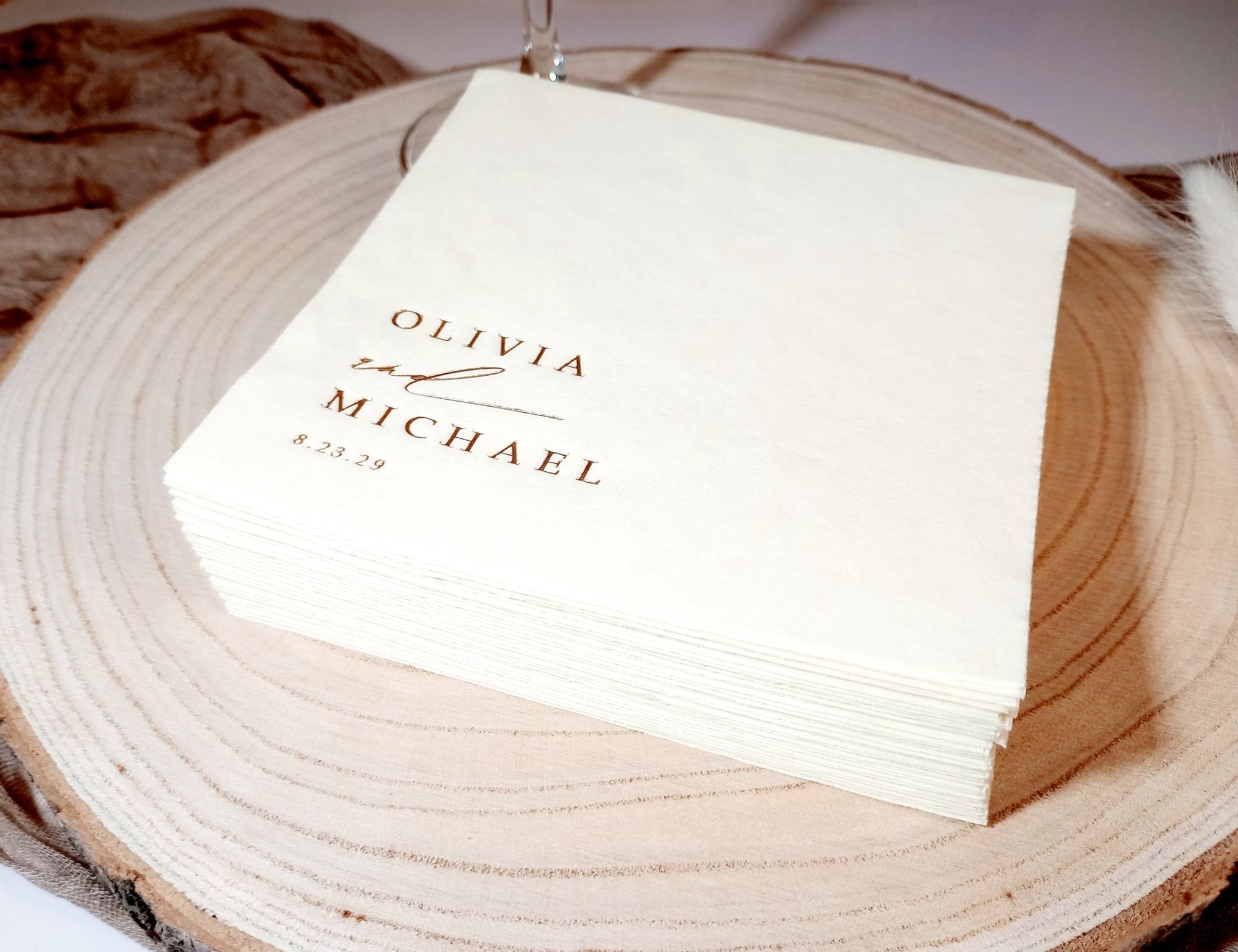 White napkin with 'Olivia & Michael' text on a wooden surface