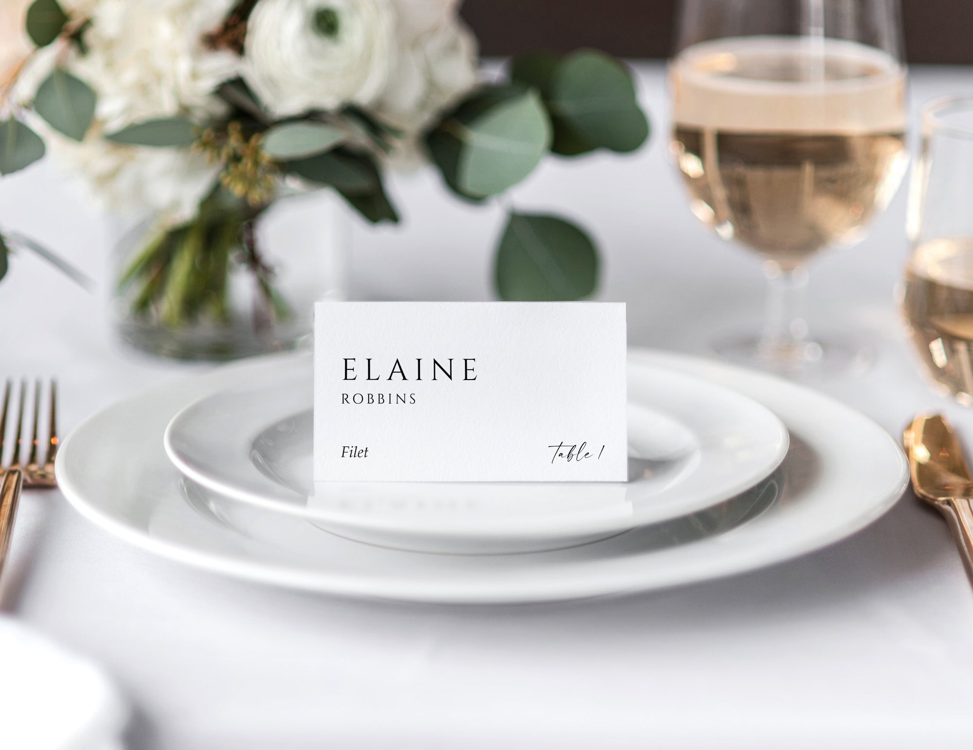 Minimalist wedding tent place card on white plate with guest name, table number, and meal choice