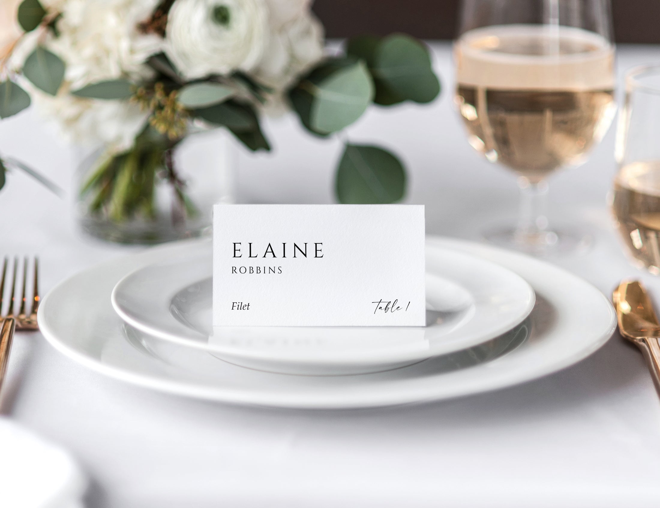 Minimalist wedding tent place card on white plate with guest name, table number, and meal choice