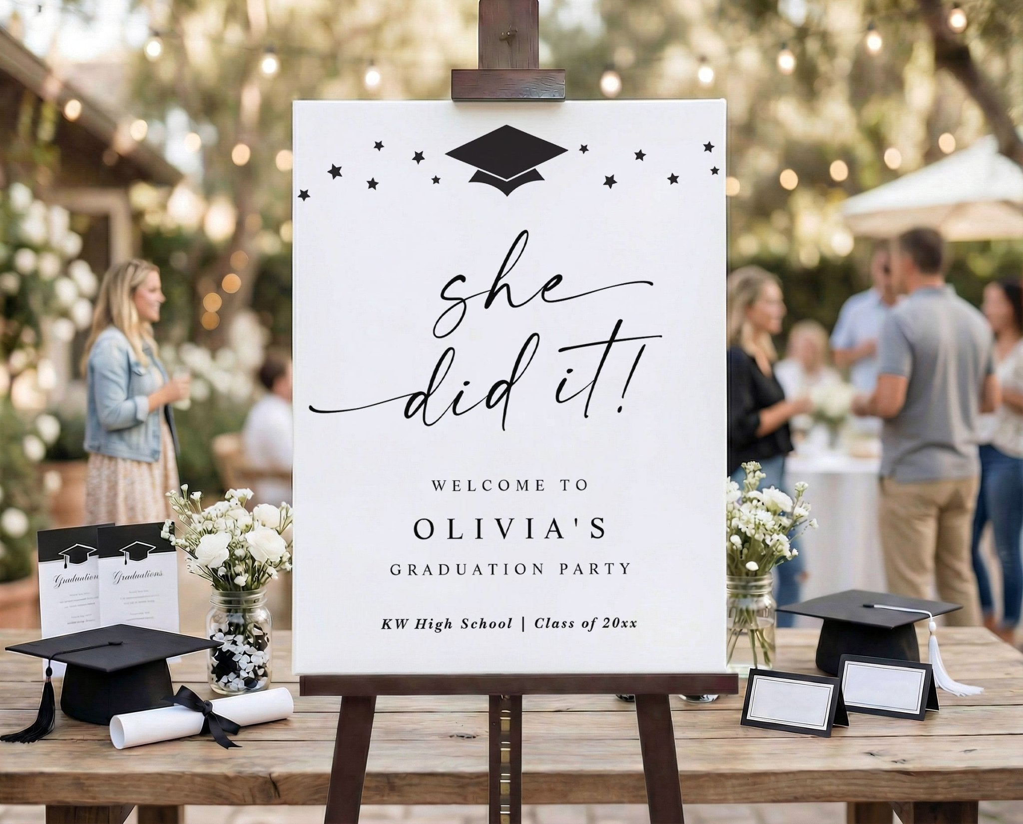 Graduation party sign on an easel with decorative elements outdoors.