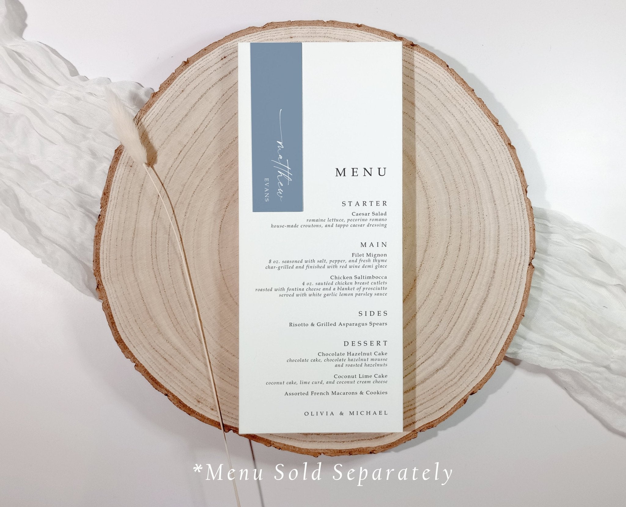 Slim name tag in blue and white layered on a printed wedding menu, displayed on a wood charger.