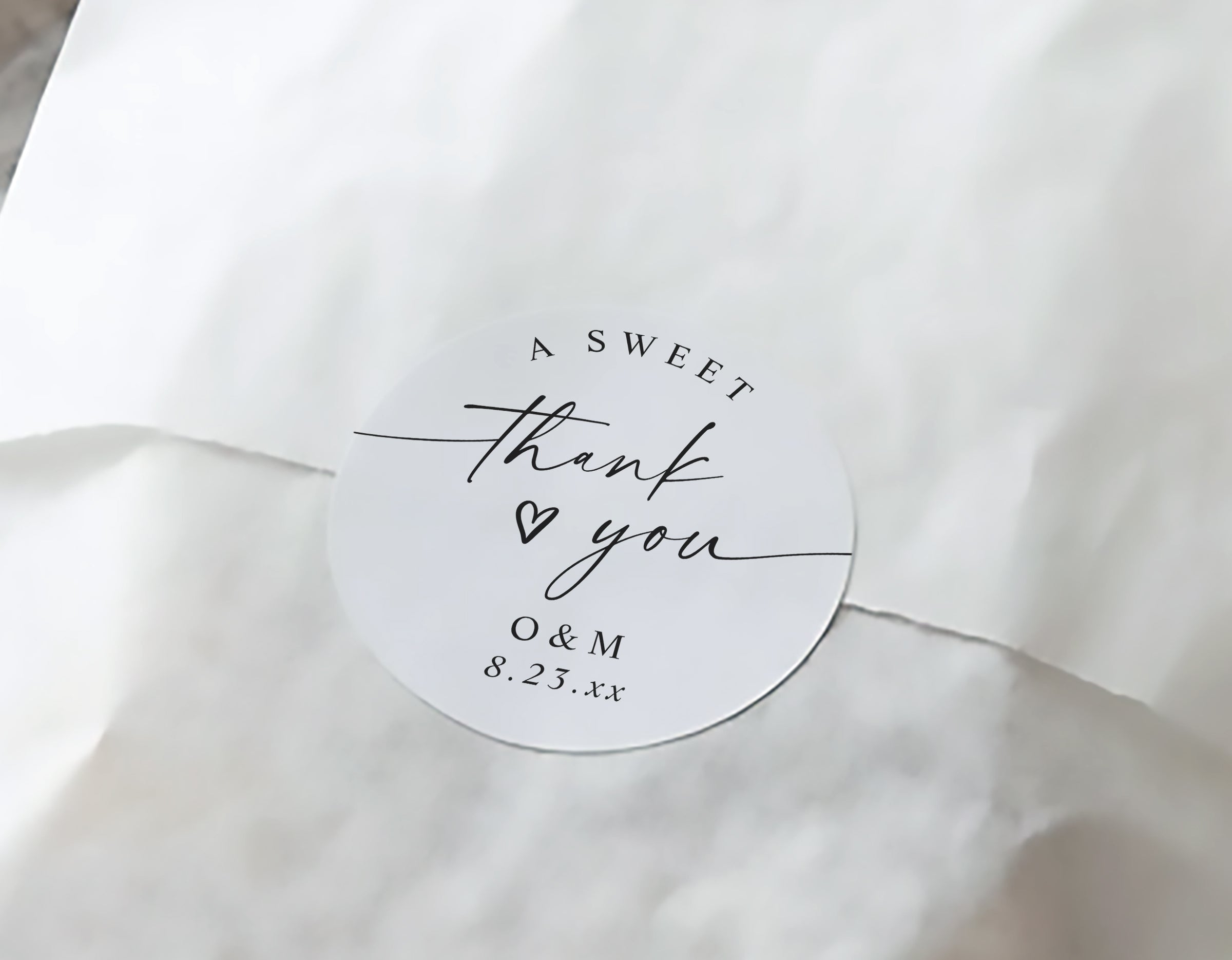 Round white label with 'A Sweet Thank You' text on a white fabric background