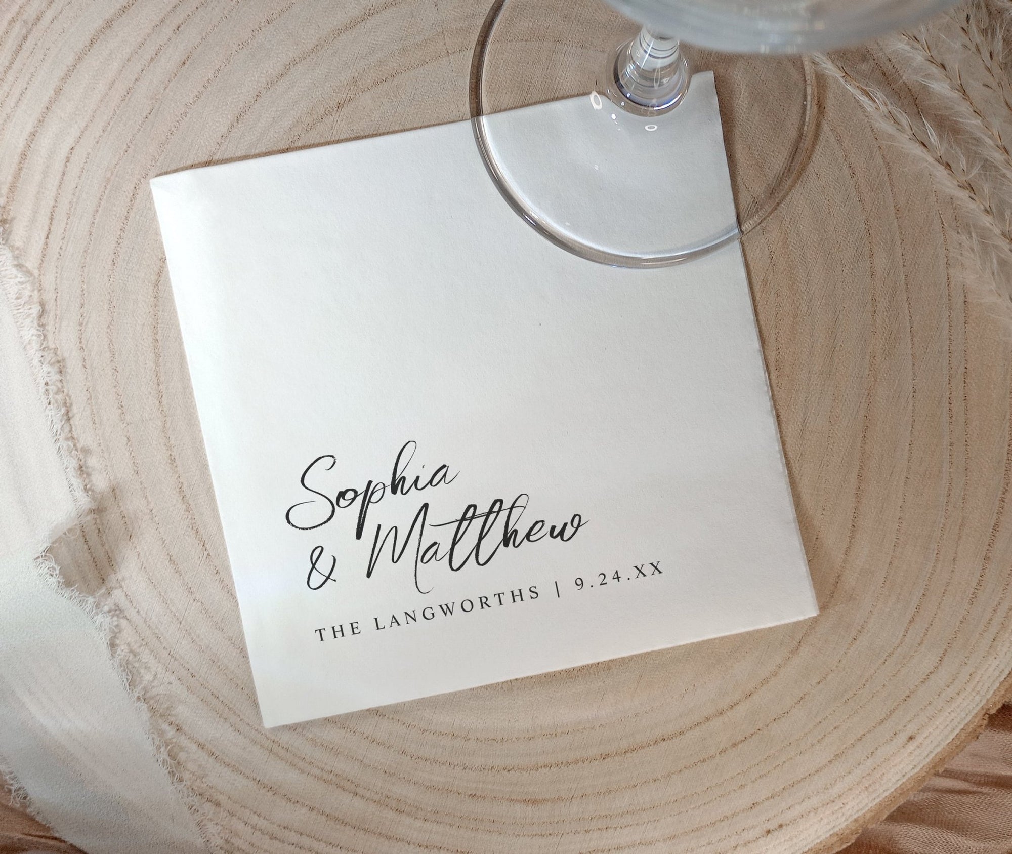 Black and white wedding napkins with handwritten names and date in modern minimalist style.