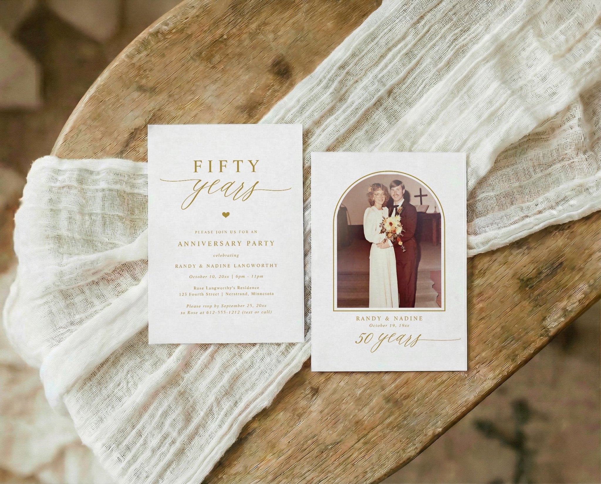 Two anniversary invitations on a wooden surface with white fabric