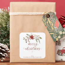 Gift wrapped in brown paper with a decorative tag and 'Merry Christmas' label, set against a red background.