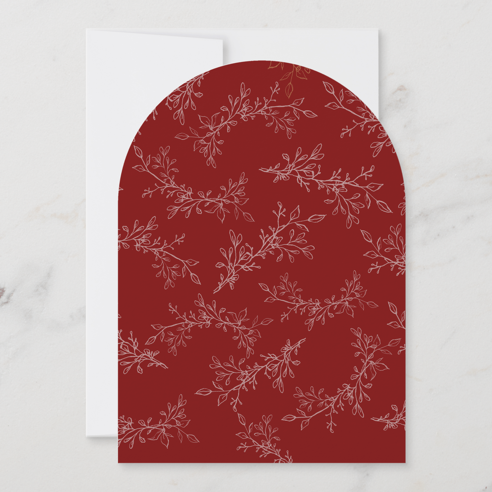 Decorative paper with a red arch and white floral pattern on a marble surface