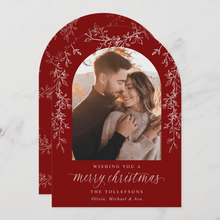 Christmas card with a red arch frame featuring a couple and text.