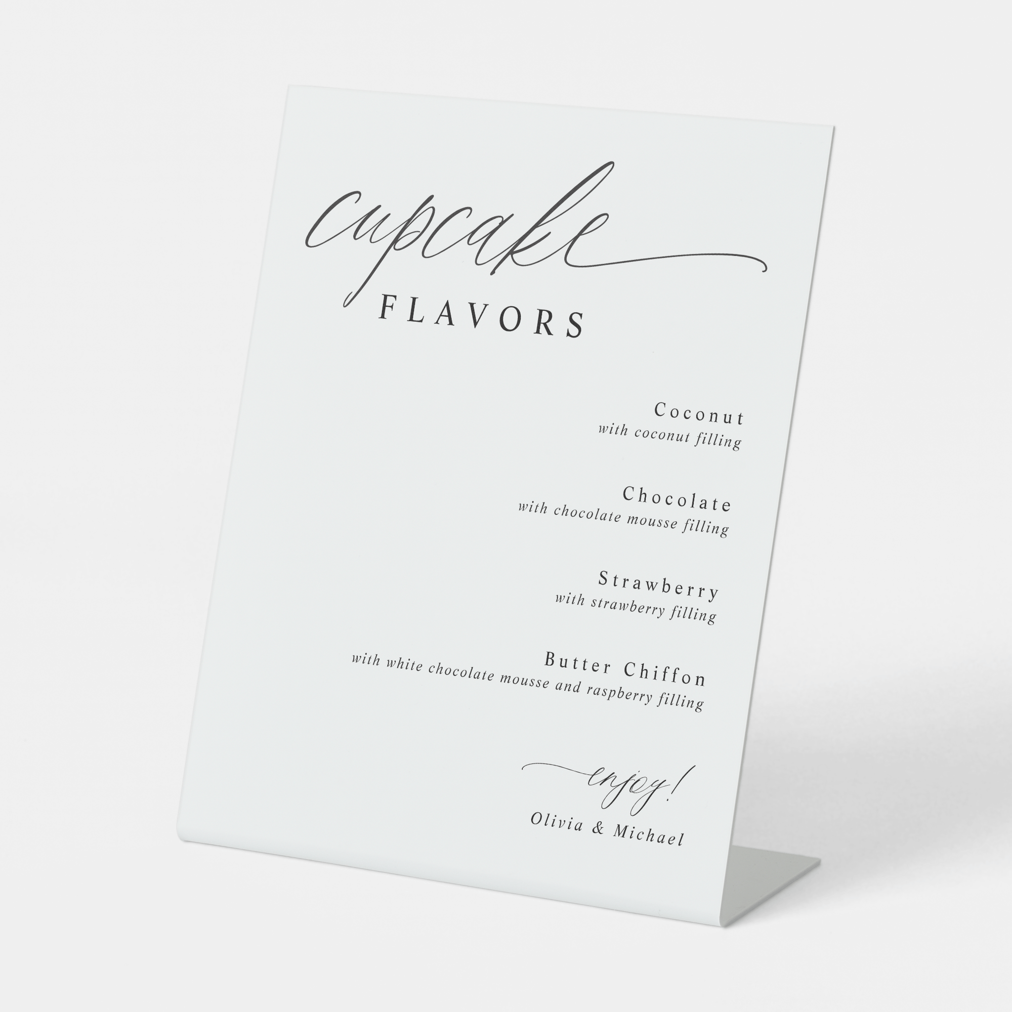 Modern calligraphy cupcake flavors sign displayed at a wedding dessert bar.