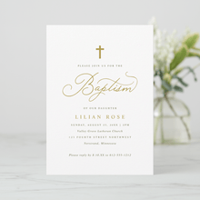 Baptism invitation card with gold text on a white background, blurred flowers in the background.