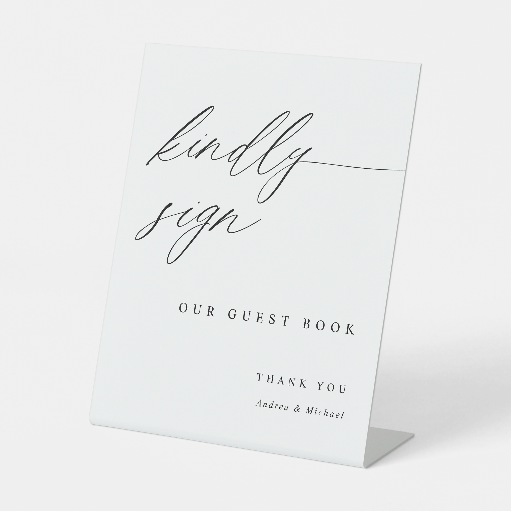 Elegant calligraphy guest book sign reading “Kindly Sign,” styled with floral wedding décor.