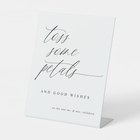 Romantic “Toss Some Petals” sign styled with floral wedding ceremony décor.