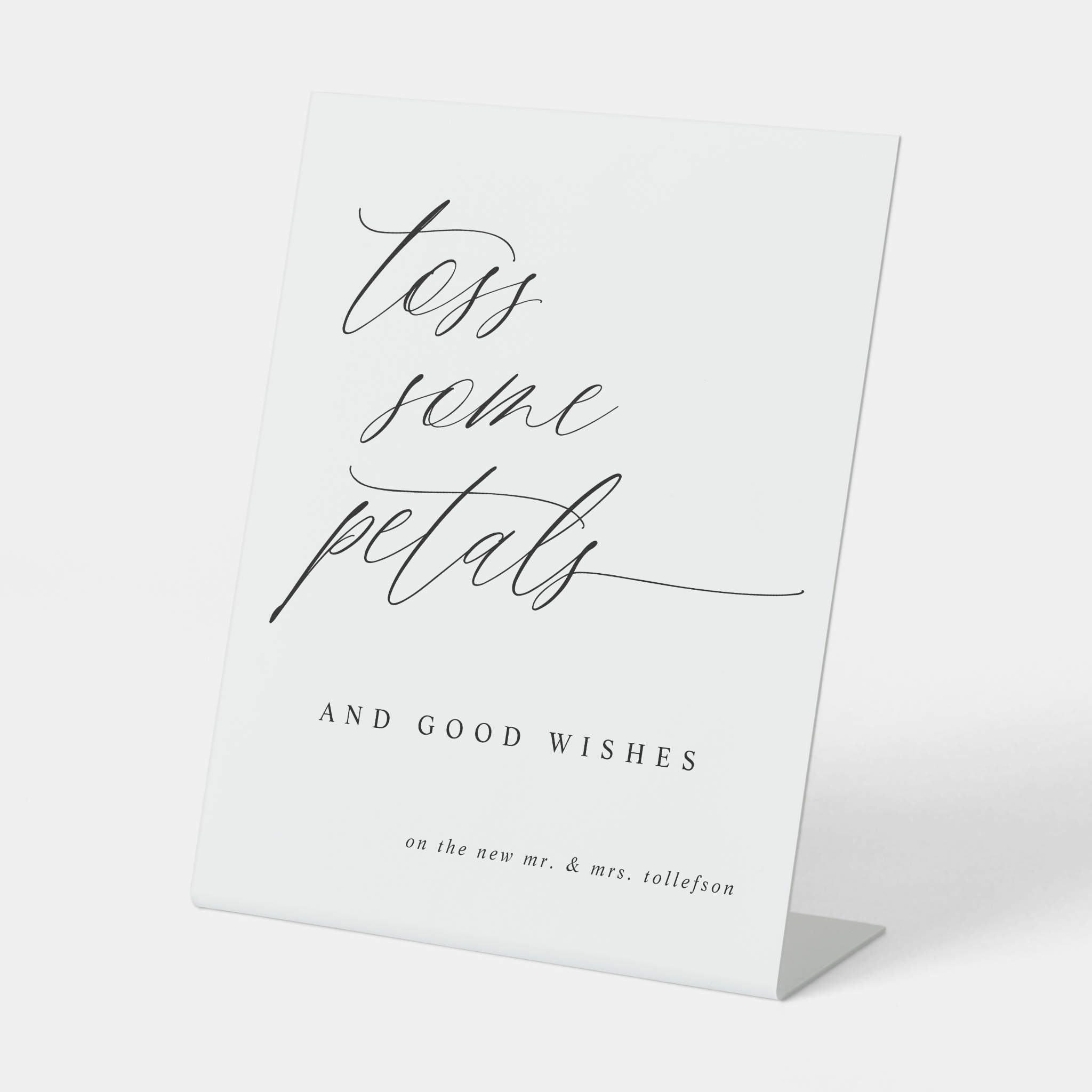 Romantic “Toss Some Petals” sign styled with floral wedding ceremony décor.