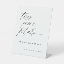 Romantic “Toss Some Petals” sign styled with floral wedding ceremony décor.