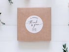 Kraft wedding favor box sealed with personalized 2-inch circle sticker that says “a sweet thank you,” customized with initials and wedding date.