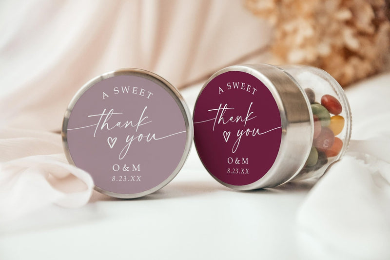 Custom circle wedding favor stickers reading “a sweet thank you,” shown on jars, available in multiple colors, personalized with initials and date.