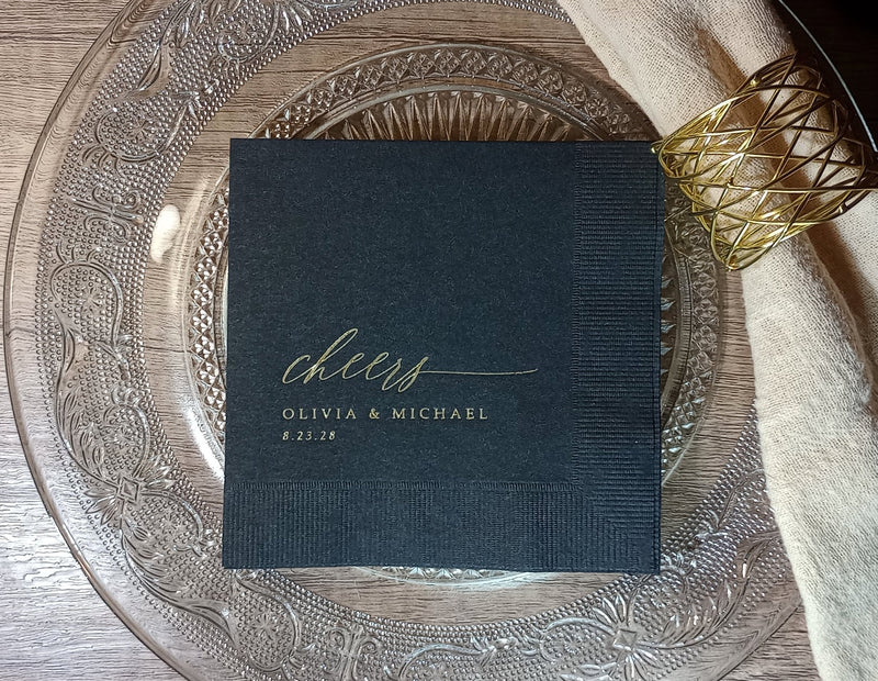 Elegant black wedding napkins with gold “cheers” script — modern, simple, and timeless for the bride and groom’s celebration.