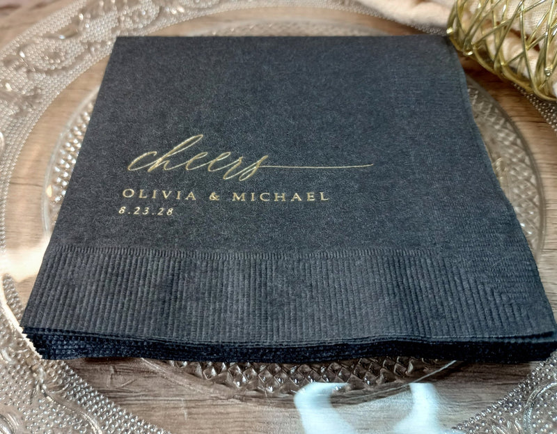 Black napkin with 'cheers Olivia & Michael' text on a decorative plate.