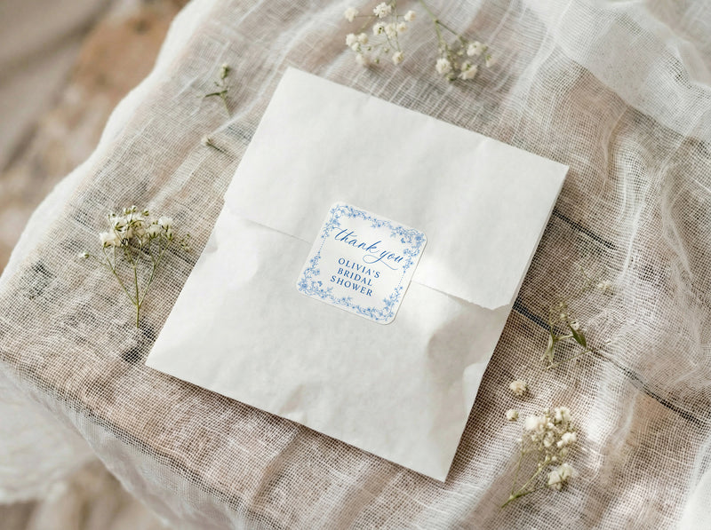 White envelope with a blue floral label on a textured fabric background