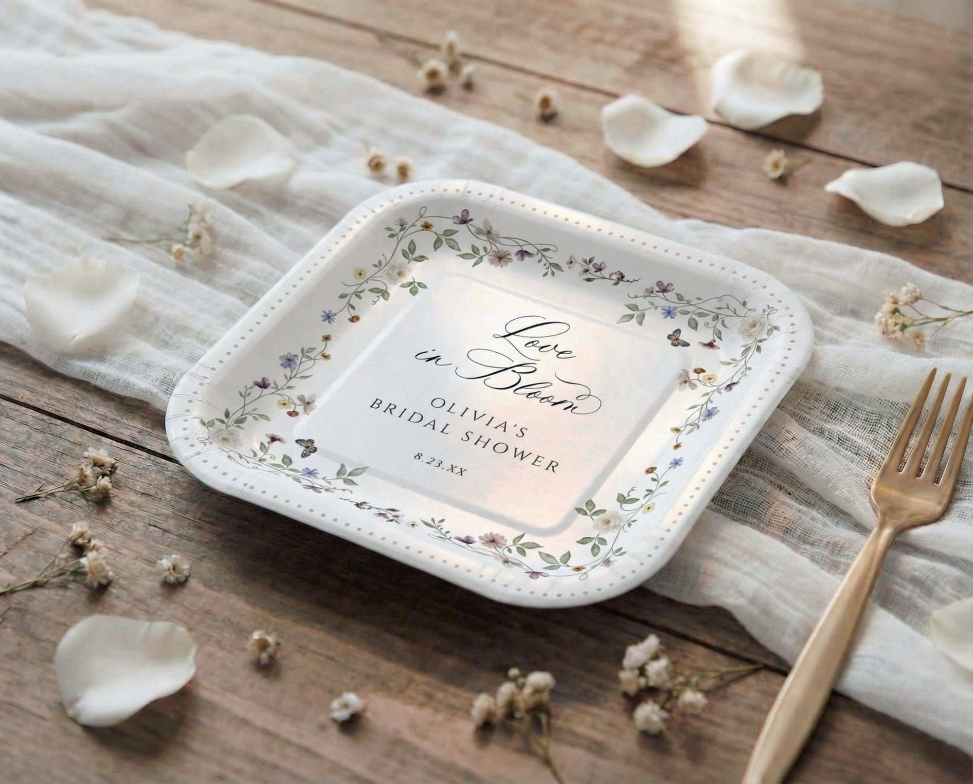 Elegant bridal shower plates in a French wildflower design on a rustic table.