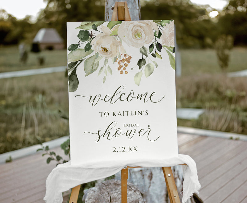 Welcome sign for a bridal shower with floral design on an easel outdoors.