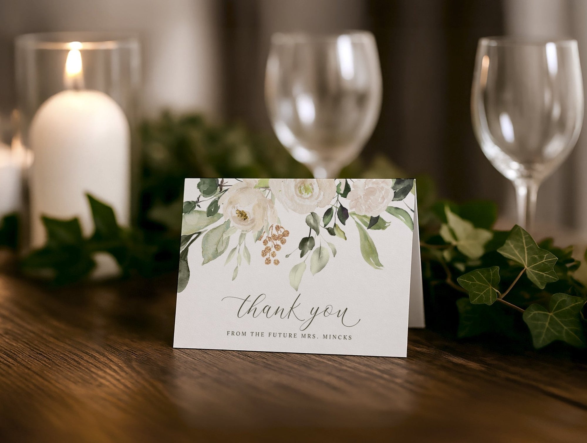 Thank you card with floral design on a table with candles and glasses