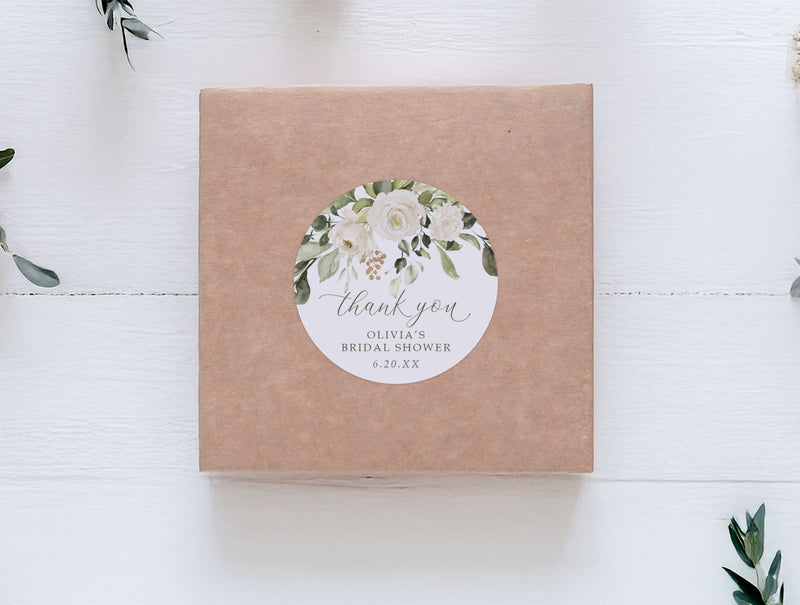round thank you sticker for bridal showers shown on a kraft box with greenery