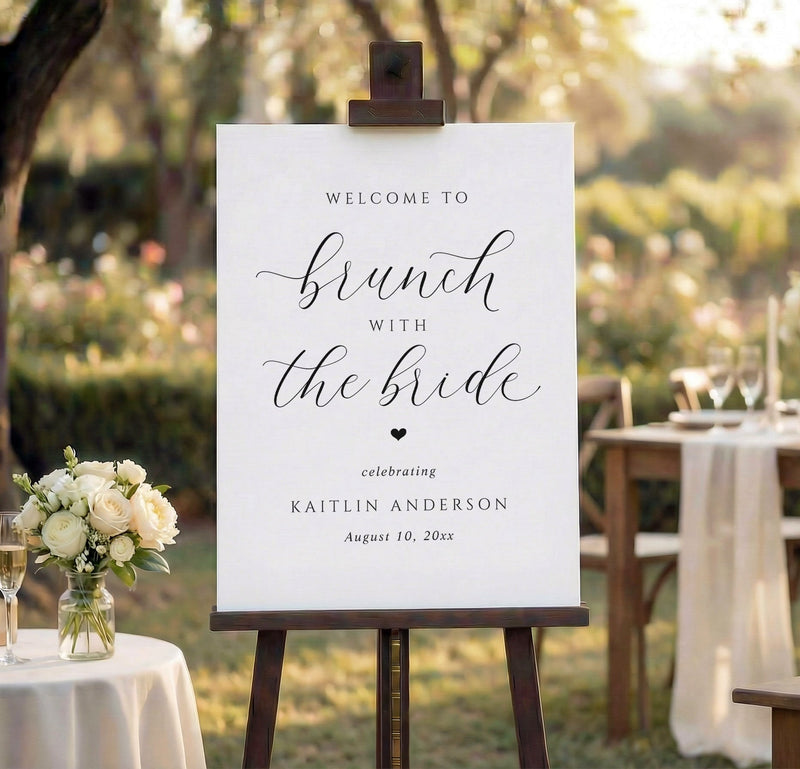Wedding brunch welcome sign on an easel with outdoor wedding setup in the background.