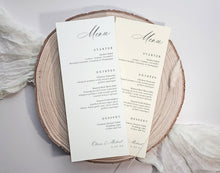 Two elegant wedding menu cards custom printed with black script and serif text on cream paper, displayed on a round natural wood slice coaster with soft white fabric in the background.
