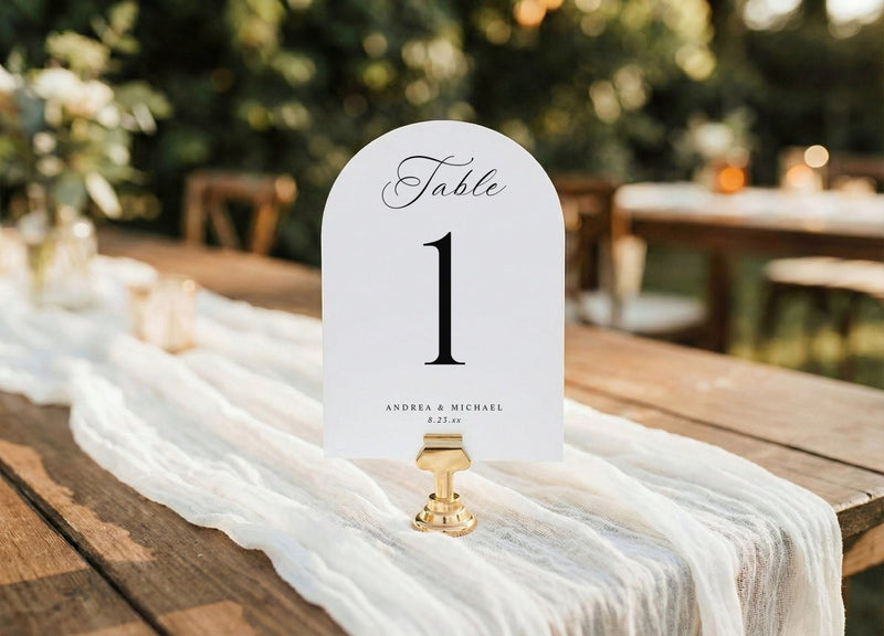 Arch table number card on a wooden table with a blurred outdoor background