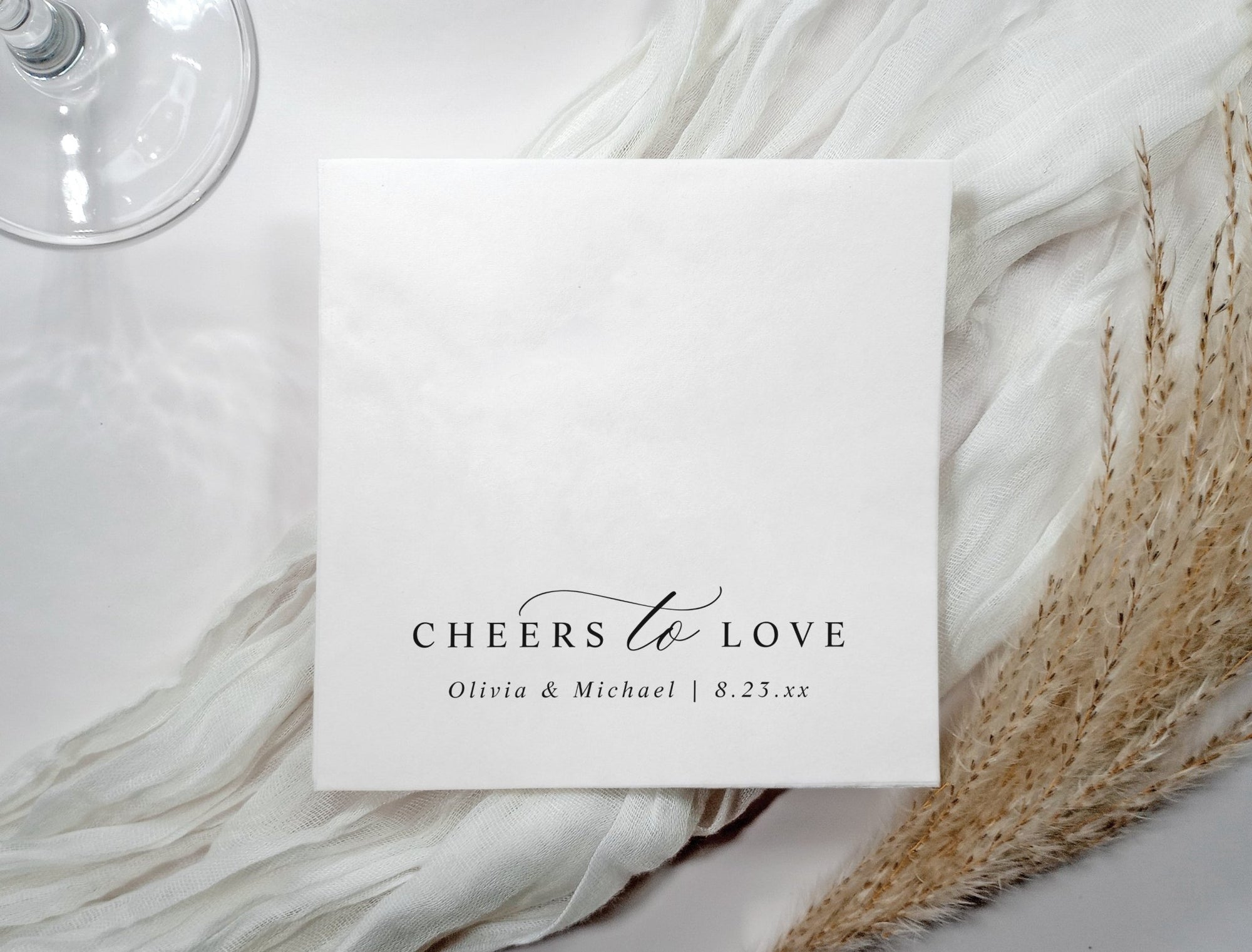 Black and white wedding napkins with elegant calligraphy text “cheers to love” in modern minimalist style