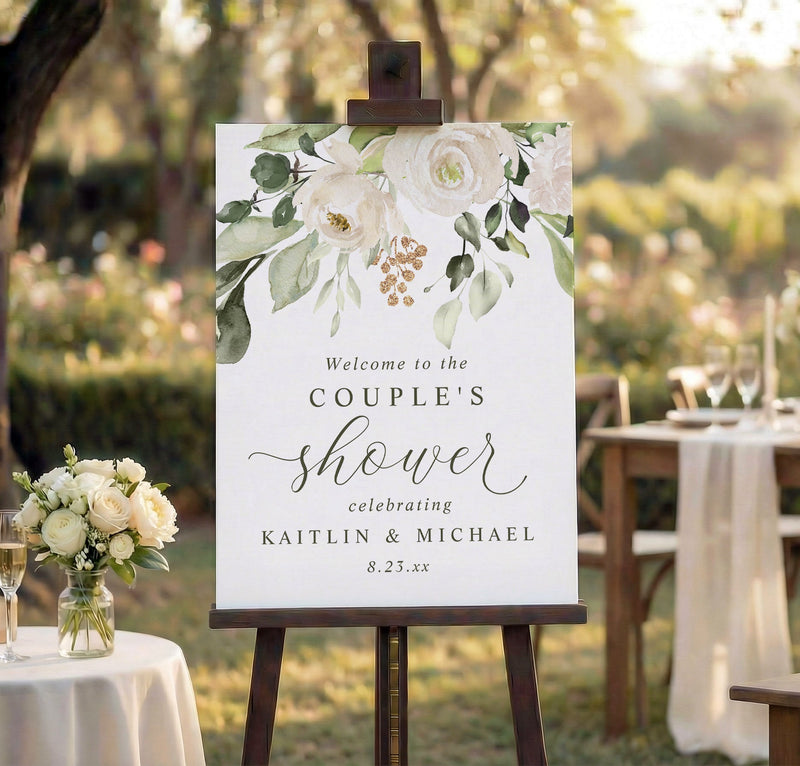 Couple’s shower welcome sign with white florals and greenery on foam board