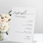 Standing “Cupcake Flavors” wedding sign in romantic calligraphy on a dessert table.