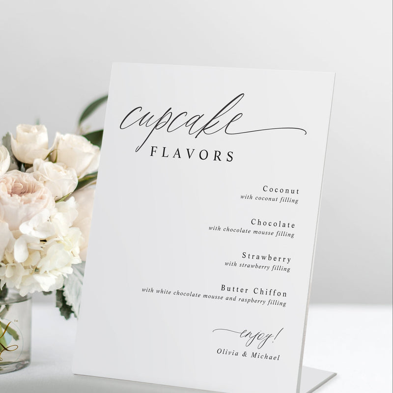 Standing “Cupcake Flavors” wedding sign in romantic calligraphy on a dessert table.