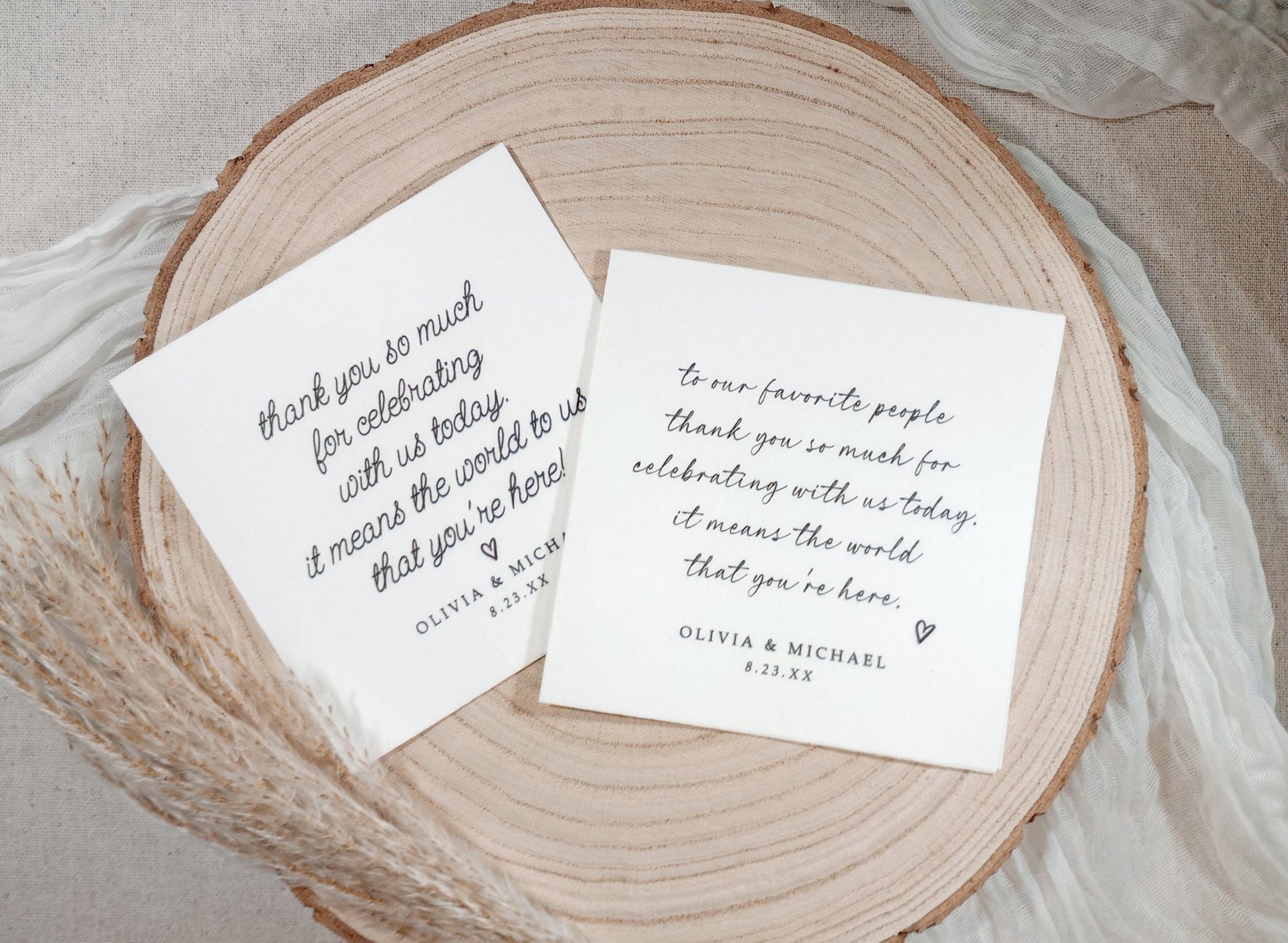 Two custom wedding napkins with love note messages in script font on wood plate
