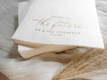 Personalized gold wedding napkin with couple’s names and date in elegant foil lettering.