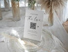 Modern wedding QR code sign with elegant handwritten script and heart for guest photo sharing.
