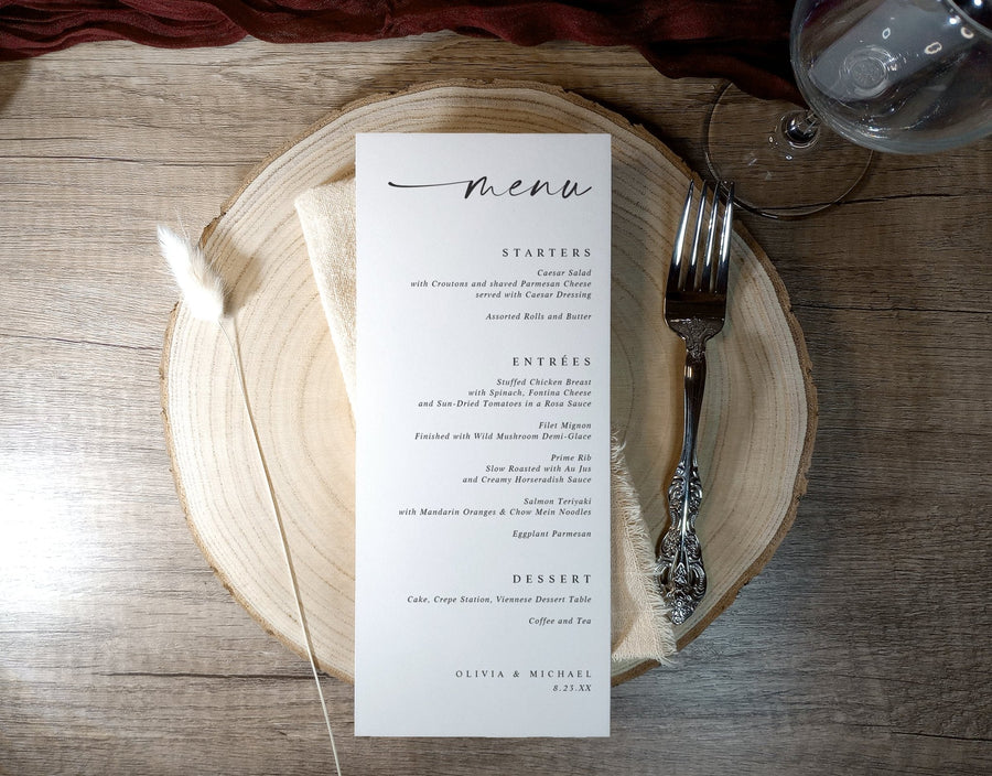 Printed menu card on a wooden plate with cutlery on a rustic wooden table