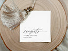 Graduation congratulations napkin with tassel on a wooden surface