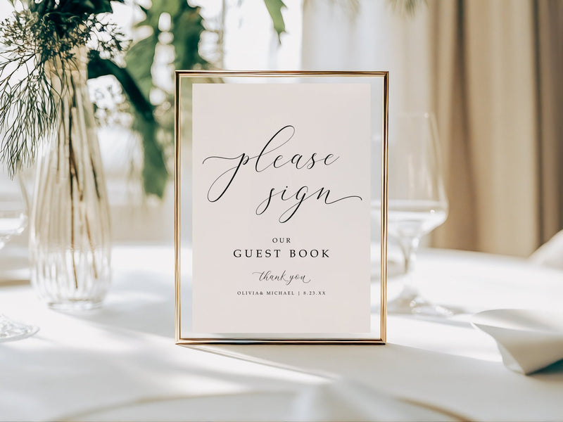 Framed wedding guest book sign on a table with decorative elements