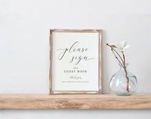 Framed guest book sign on a wooden shelf with a vase containing a plant