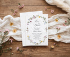 Bridal Shower invitation card with floral design on a wooden surface with flowers around
