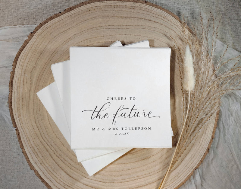 Black and white engagement napkin with “cheers to the future” and couple’s names